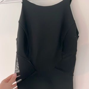 Black cocktail dress with see through mesh inserts.